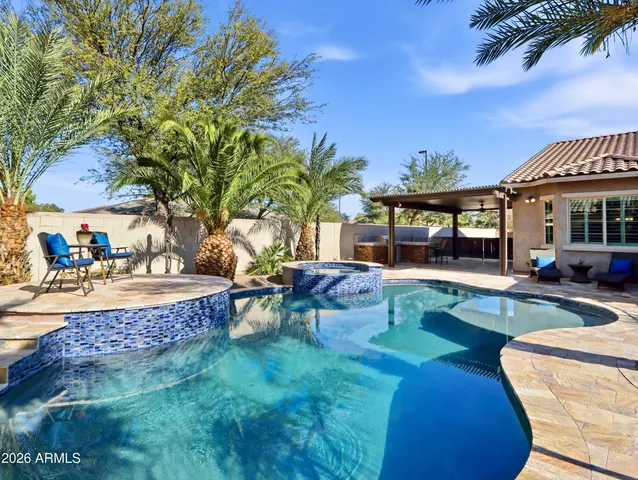 a living room with furniture kitchen view and a chandelier