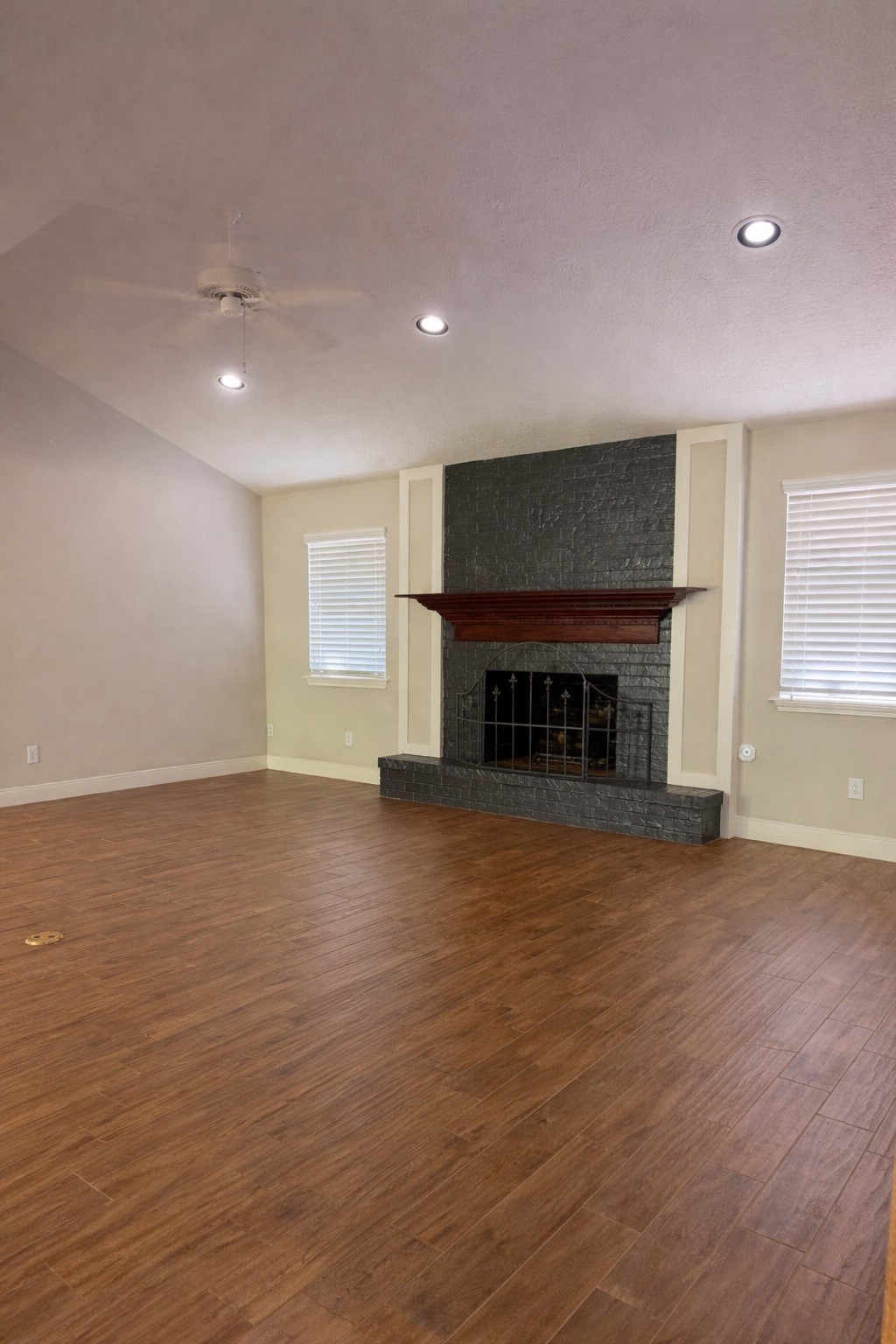 19103 Whitewood Drive Spring, TX 77373 - Photo 10 of 30 an empty room with wooden floor fireplace and windows