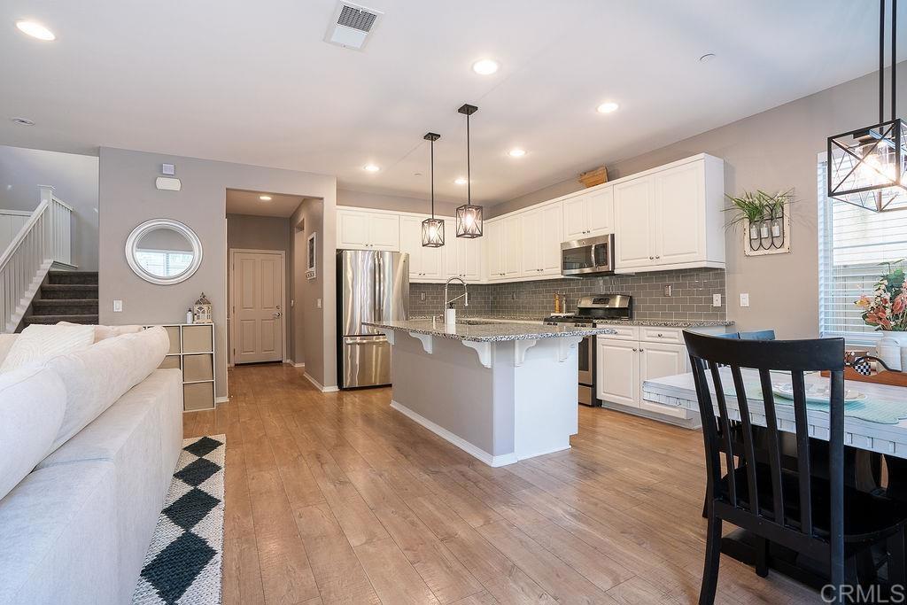1132 Cherry Tree Lane Vista, CA 92084 - Photo 12 of 39 a kitchen with stainless steel appliances kitchen island granite countertop a stove a sink and a refrigerator