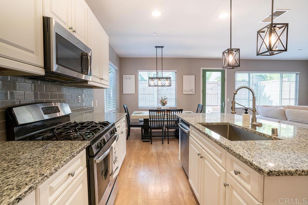 1132 Cherry Tree Lane Vista, CA 92084 - Photo 13 of 39 a kitchen with granite countertop a stove a sink and a microwave