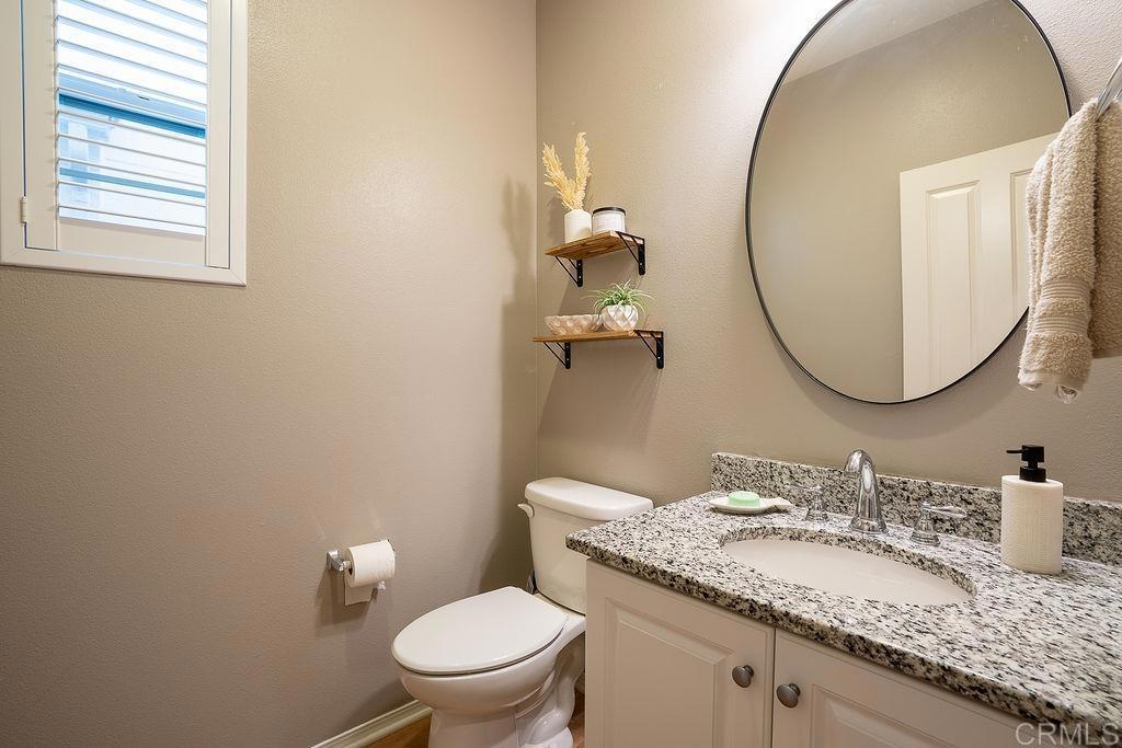1132 Cherry Tree Lane Vista, CA 92084 - Photo 15 of 39 a bathroom with a granite countertop toilet a sink and a mirror