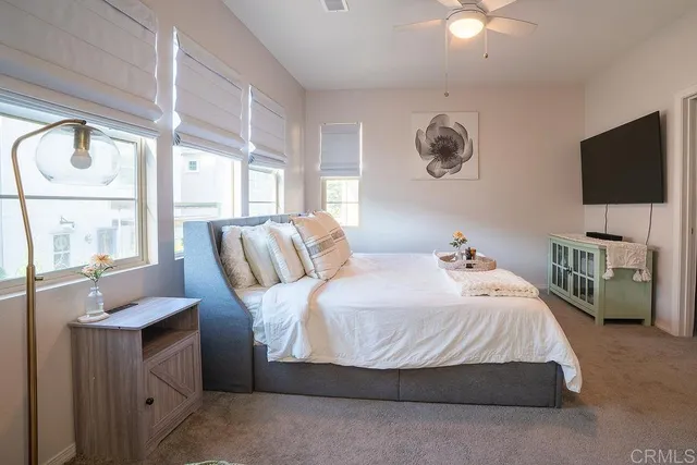 a bedroom with a large bed and a flat tv screen on dresser