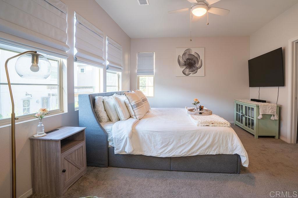1132 Cherry Tree Lane Vista, CA 92084 - Photo 18 of 39 a bedroom with a large bed and a flat tv screen on dresser