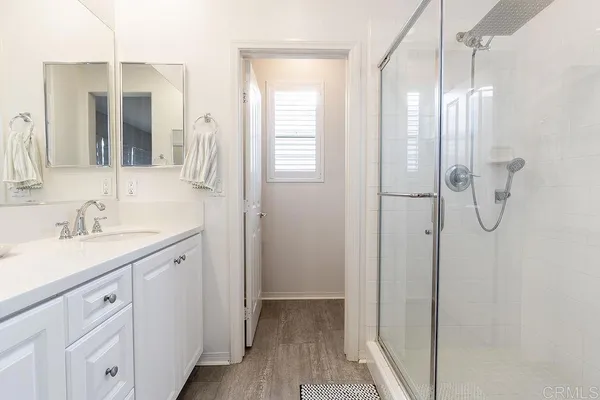 a bathroom with a double vanity sink a mirror and a shower