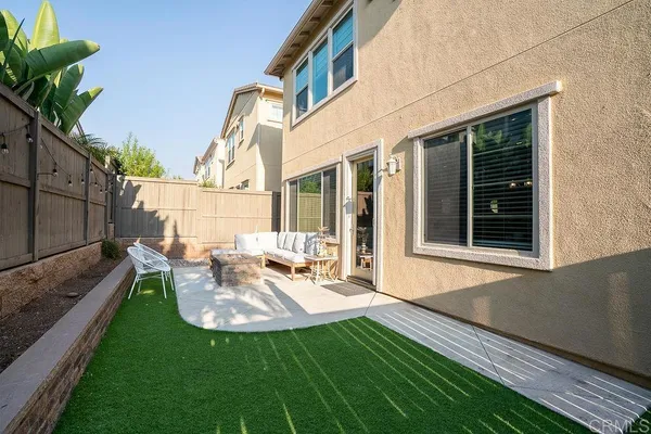 a view of a chair and table in backyard of the house