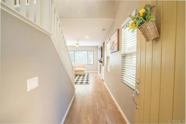 a view of a hallway with wooden floor and staircase
