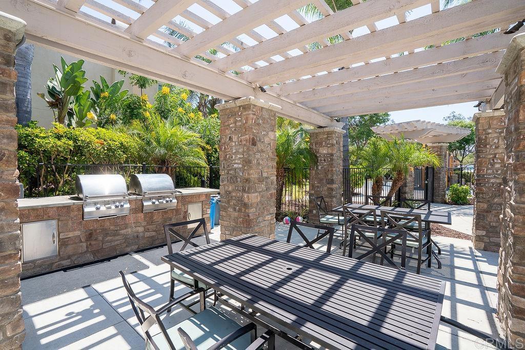 1132 Cherry Tree Lane Vista, CA 92084 - Photo 37 of 39 a view of a patio with table and chairs barbeque potted plants and large tree