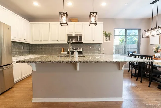 a kitchen with stainless steel appliances granite countertop a sink a stove and a refrigerator
