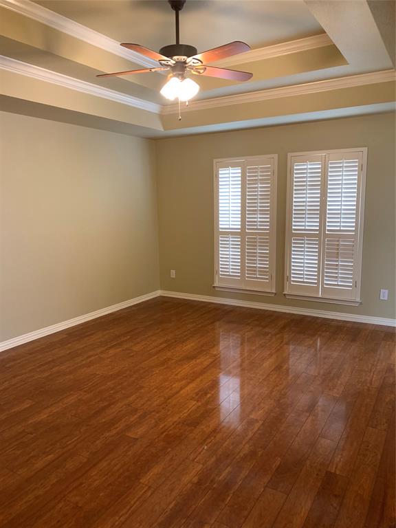 4914 Shadowood Road Colleyville, TX 76034 - Photo 7 of 28 Unfurnished room featuring a raised ceiling, crown molding, a ceiling fan, and dark wood-style flooring