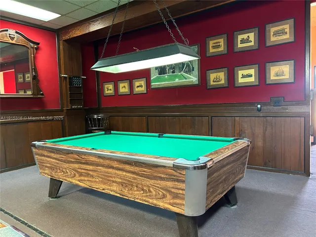 a room with pool table and windows