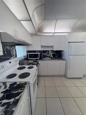 a kitchen with a sink a stove and cabinets