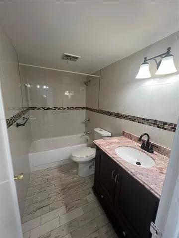 a bathroom with a bathtub a sink a toilet a mirror and vanity