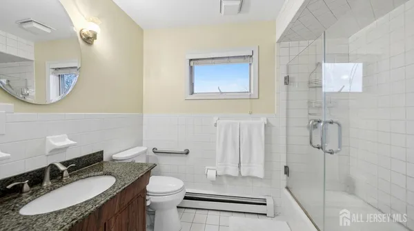 a bathroom with a granite countertop sink toilet a mirror and shower
