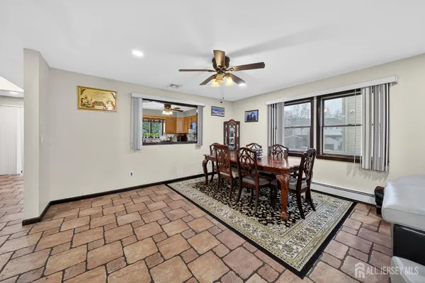 a dining room with chandelier fan and wooden floor