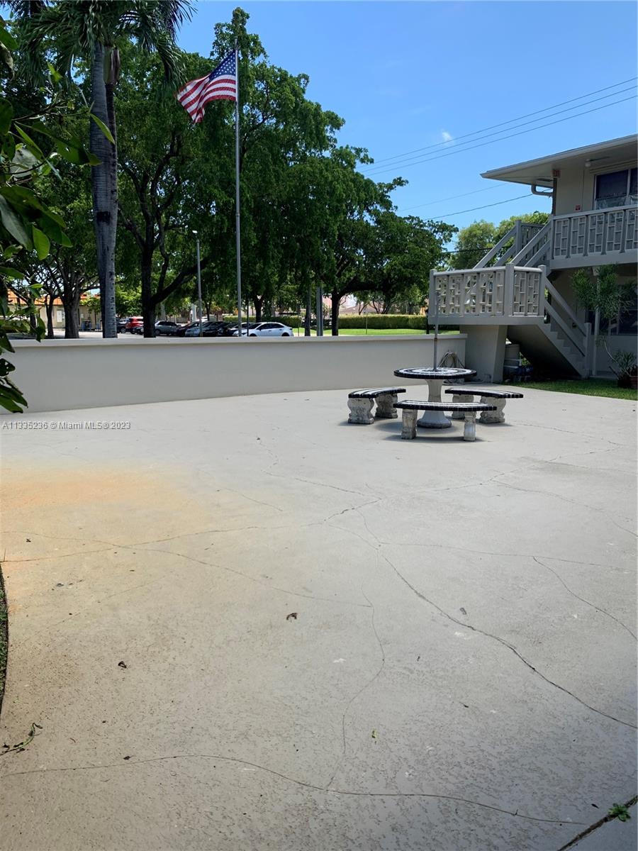 3500 Harrison Street, Unit 8 Hollywood, FL 33021 - Photo 19 of 59 a view of a terrace with a bench and trees around