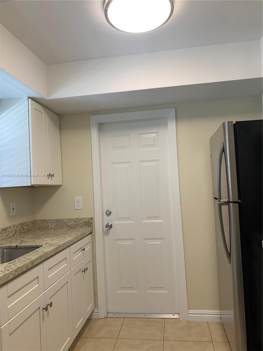 3500 Harrison Street, Unit 8 Hollywood, FL 33021 - Photo 32 of 59 a kitchen with a refrigerator and cabinets