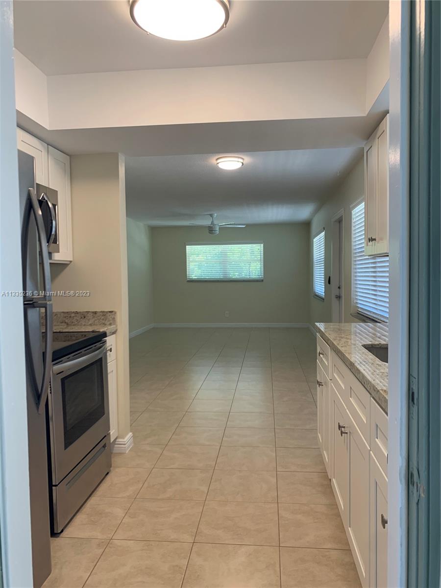 3500 Harrison Street, Unit 8 Hollywood, FL 33021 - Photo 35 of 59 a kitchen with stainless steel appliances granite countertop a stove a sink and a refrigerator