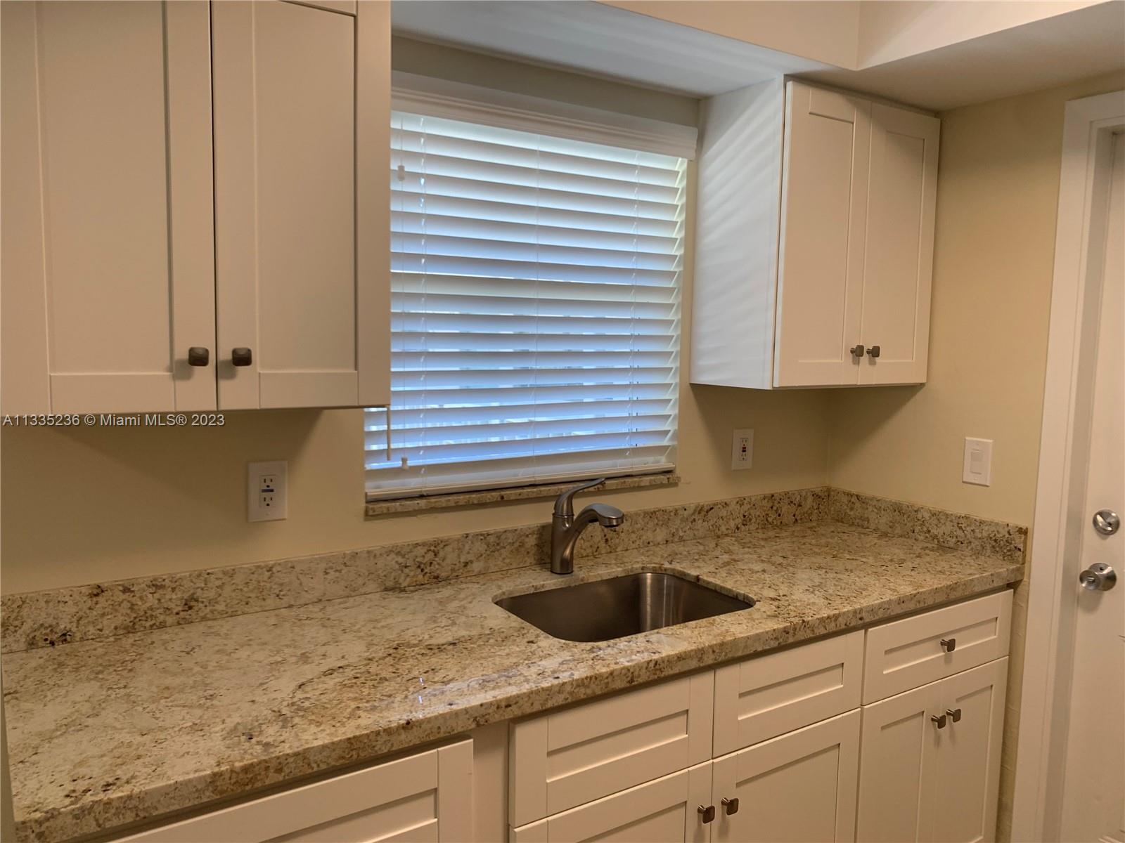 3500 Harrison Street, Unit 8 Hollywood, FL 33021 - Photo 37 of 59 a kitchen with granite countertop white cabinets and a sink