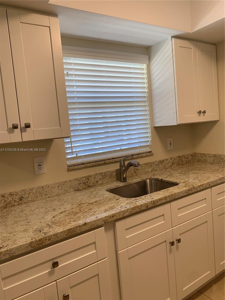 3500 Harrison Street, Unit 8 Hollywood, FL 33021 - Photo 38 of 59 a kitchen with granite countertop white cabinets and a sink