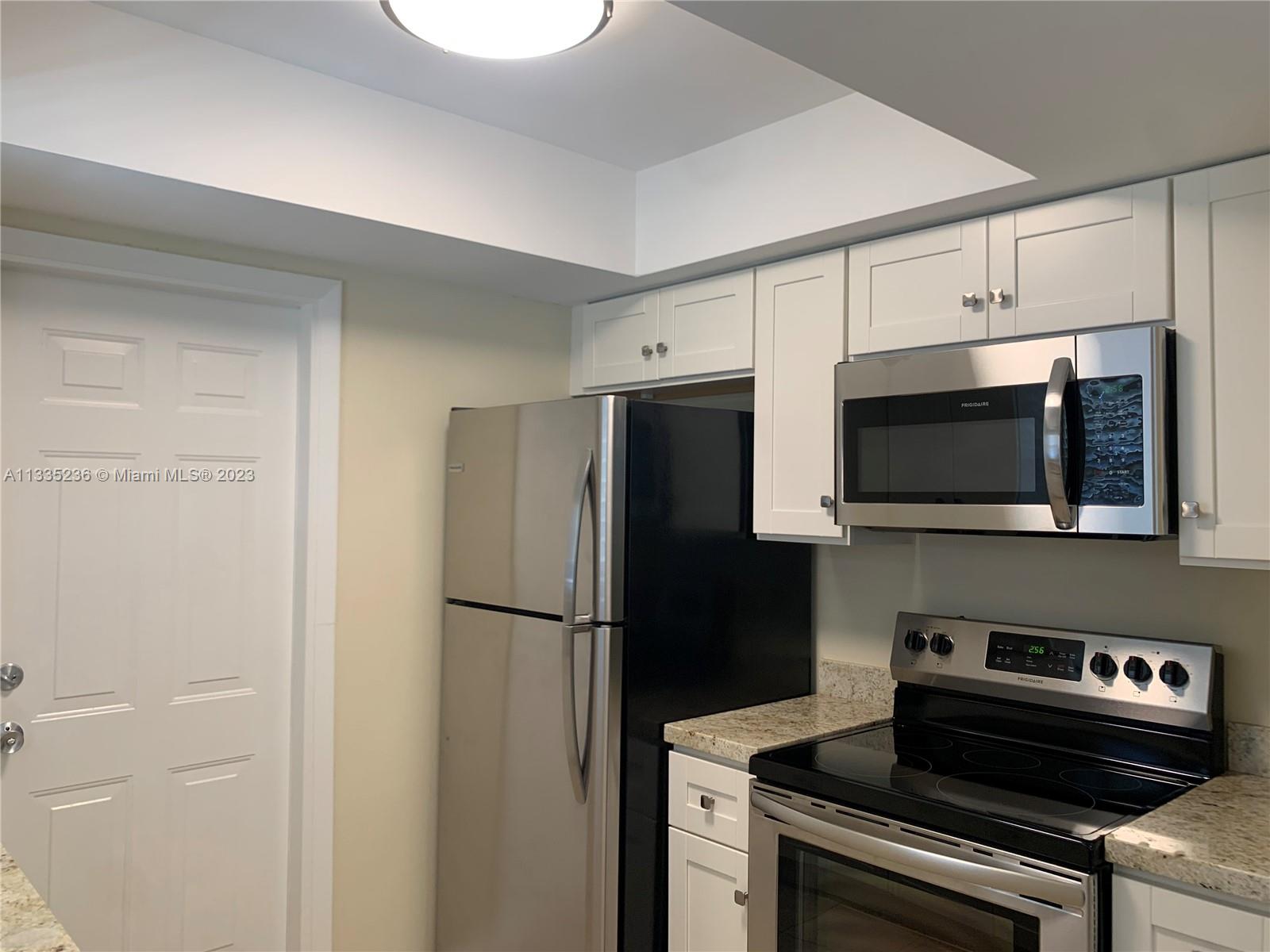 3500 Harrison Street, Unit 8 Hollywood, FL 33021 - Photo 39 of 59 a kitchen with stainless steel appliances a refrigerator a stove a microwave and cabinets