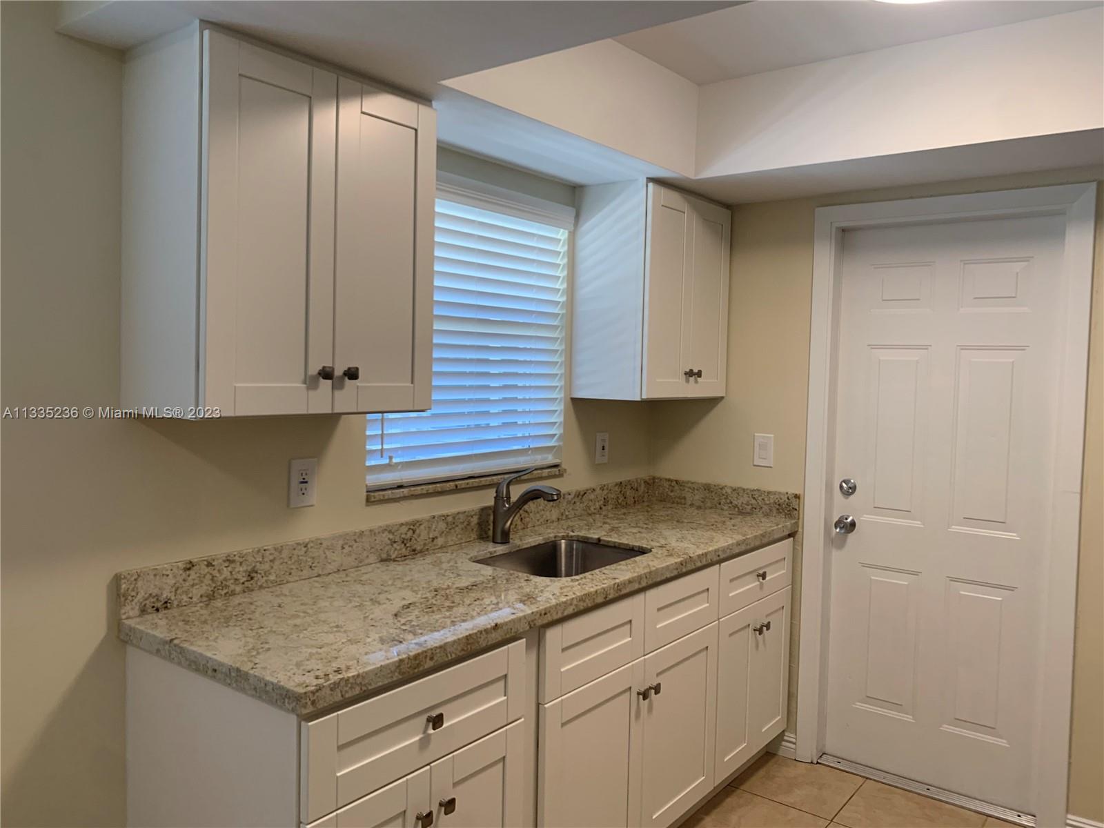 3500 Harrison Street, Unit 8 Hollywood, FL 33021 - Photo 4 of 59 a kitchen with granite countertop white cabinets and a sink