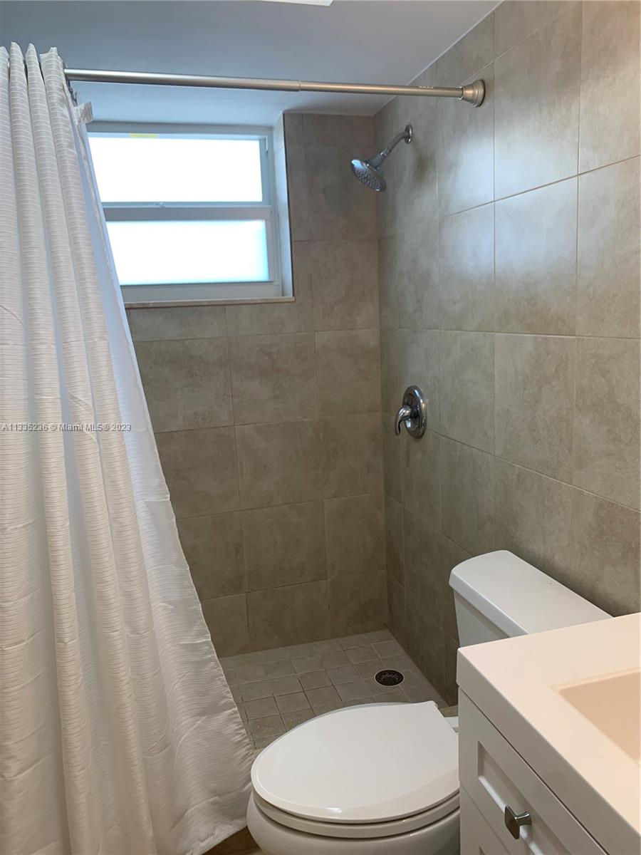 3500 Harrison Street, Unit 8 Hollywood, FL 33021 - Photo 51 of 59 a white toilet sitting next to a bath tub and a shower