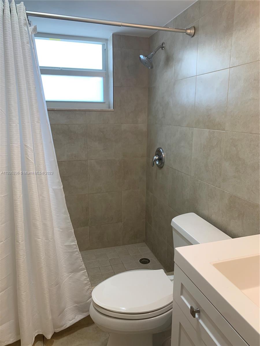 3500 Harrison Street, Unit 8 Hollywood, FL 33021 - Photo 52 of 59 a white toilet sitting next to a bathroom sink and a shower