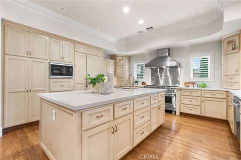 a kitchen with granite countertop a sink stainless steel appliances and white cabinets