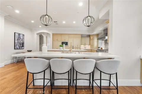 a kitchen with stainless steel appliances granite countertop a table chairs and chandelier