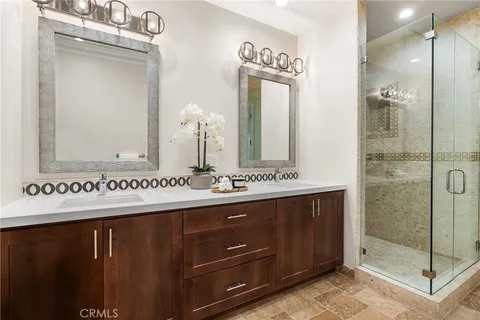 a bathroom with a double vanity sink mirror and shower