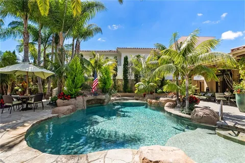 a view of a backyard with a patio and swimming pool