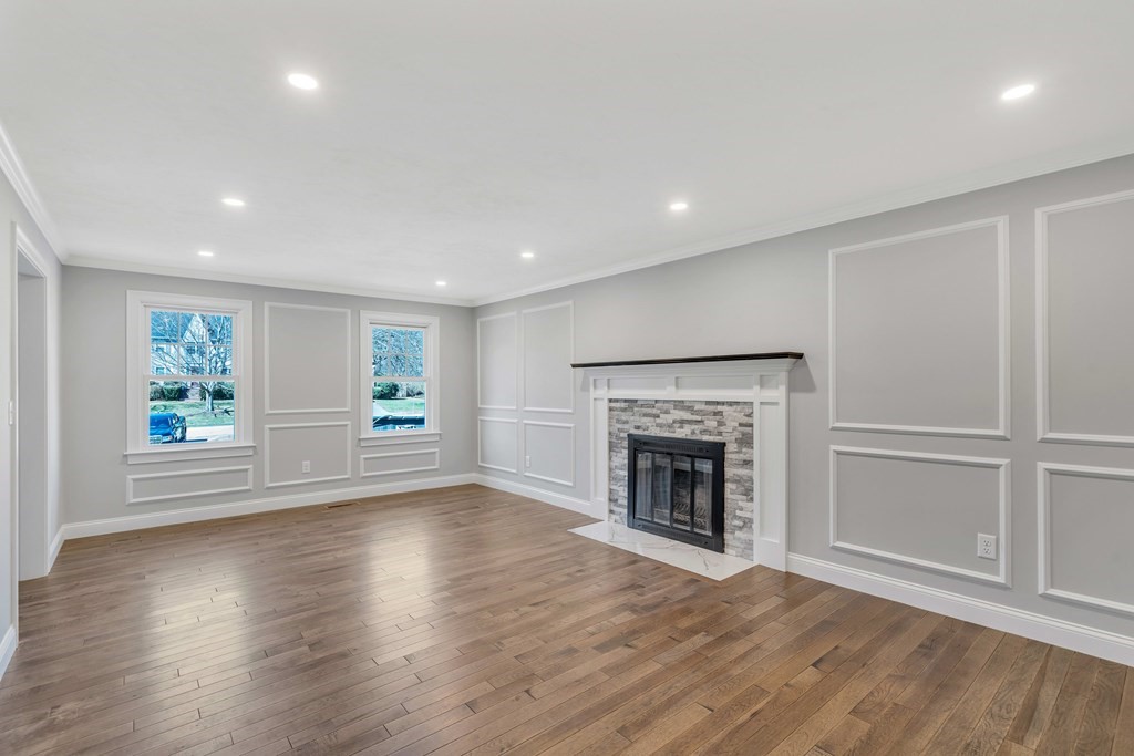 74 Robert Road Stow, MA 01775 - Photo 19 of 36 an empty room with wooden floor fireplace and windows