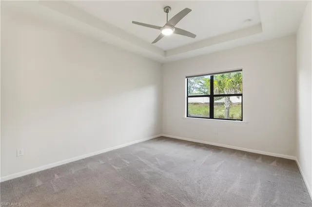 an empty room with a window and a ceiling fan