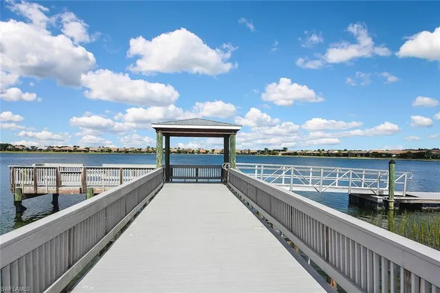 a view of a white house with a big yard and potted plants