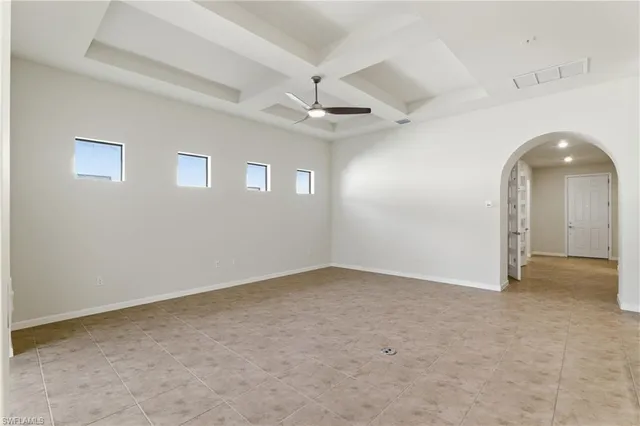an empty room with a ceiling fan and a window