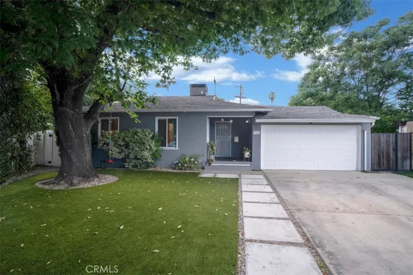 a front view of a house with a garden and yard