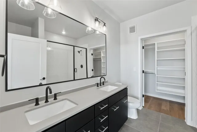 a bedroom with a large bed and a flat tv screen on dresser