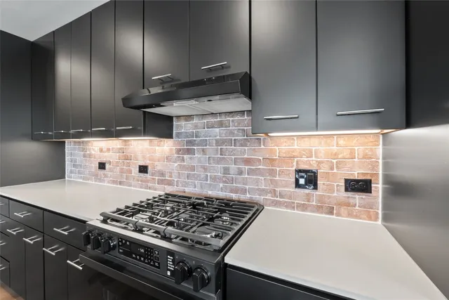 a kitchen with kitchen island granite countertop a sink counter top space and stainless steel appliances