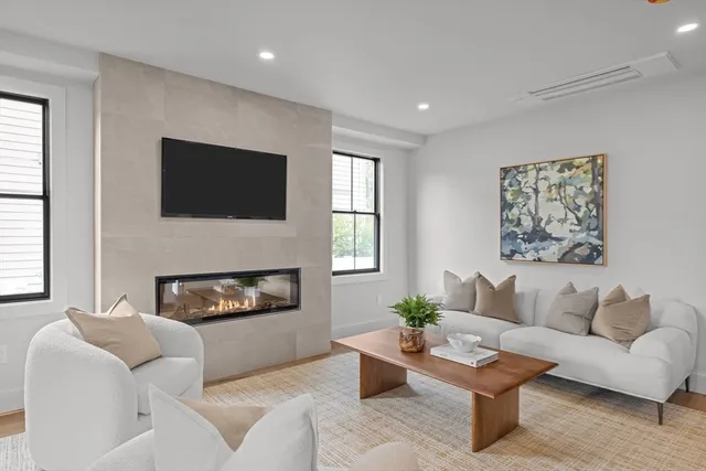 a living room with furniture a fireplace and a flat screen tv