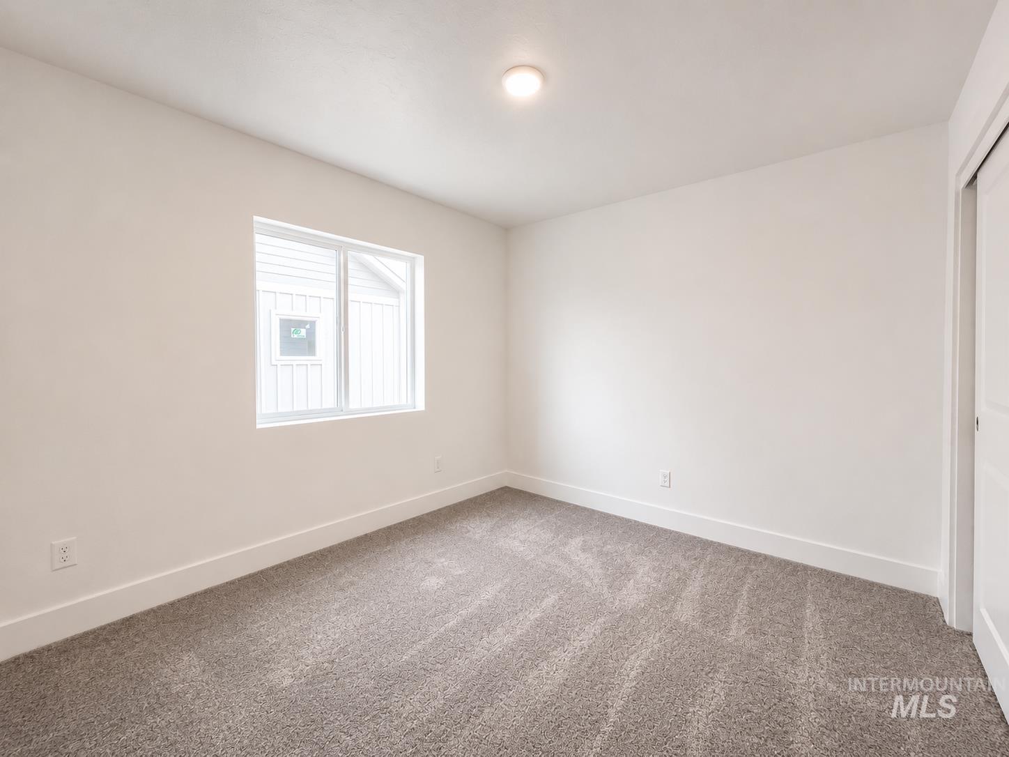 8098 West Fern Street Eagle, ID 83616 - Photo 13 of 22 Carpeted interior space featuring a window with white trim, white walls, and a ceiling-mounted light fixture