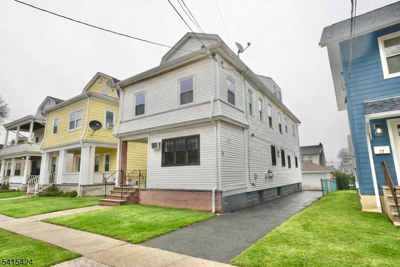 81 Berkeley Avenue Bloomfield, NJ 07003 - Photo 1 of 43 a view of a white house with a big yard and large windows