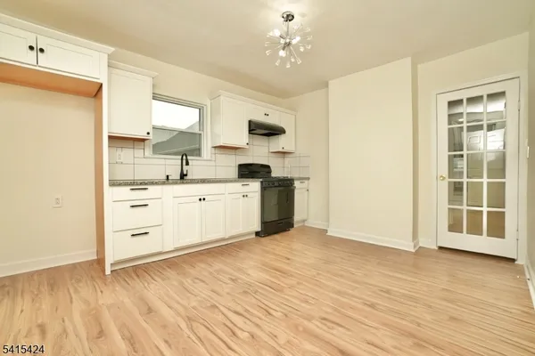 a view of a kitchen with wooden floor and a sink