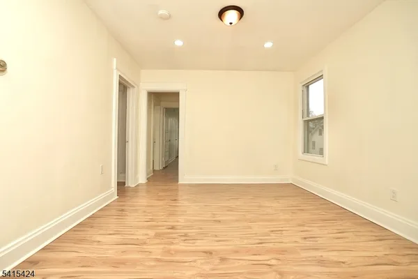 a view of an empty room with wooden floor