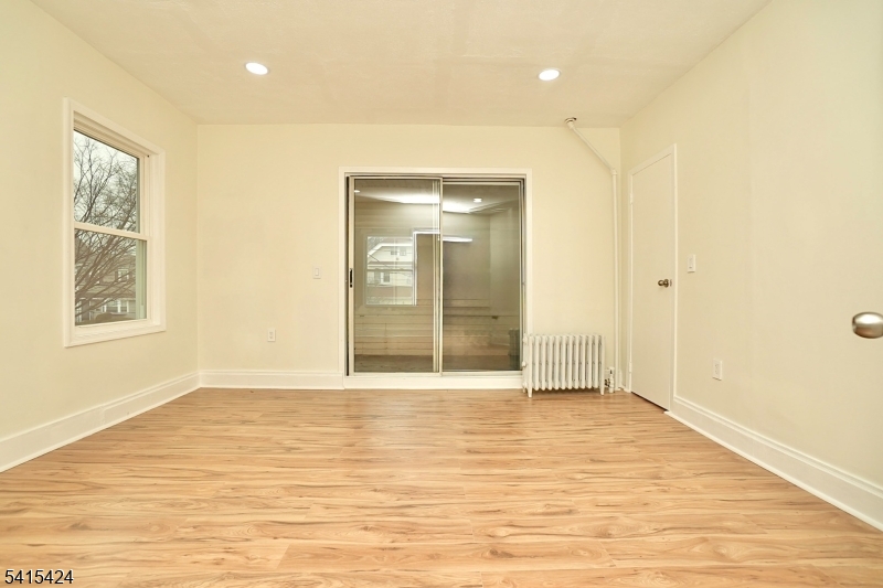 81 Berkeley Avenue Bloomfield, NJ 07003 - Photo 20 of 43 a view of an empty room with wooden floor and a window