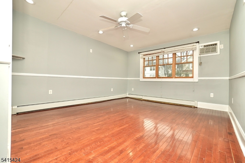 81 Berkeley Avenue Bloomfield, NJ 07003 - Photo 2 of 43 an empty room with wooden floor and windows