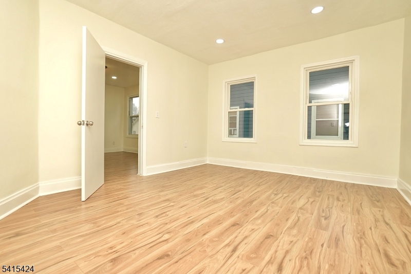 81 Berkeley Avenue Bloomfield, NJ 07003 - Photo 26 of 43 a view of an empty room with wooden floor and a window