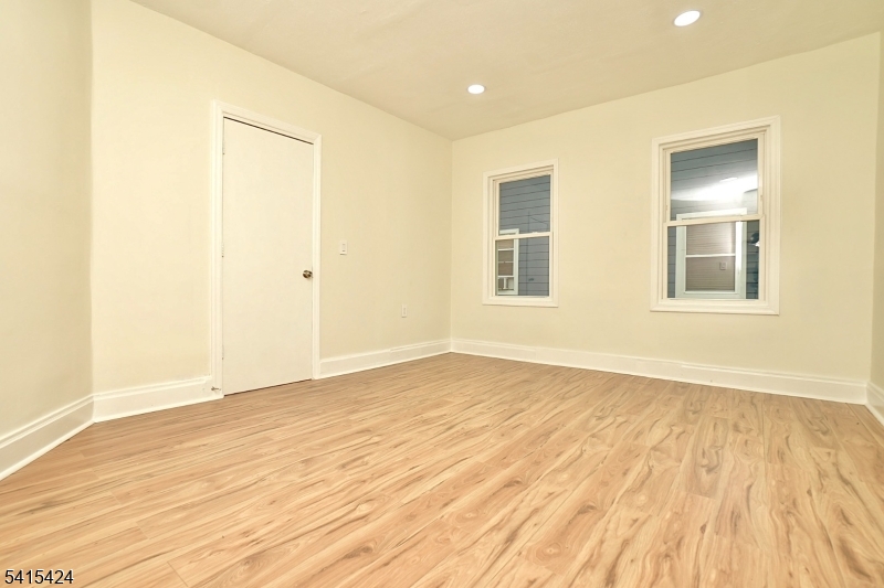 81 Berkeley Avenue Bloomfield, NJ 07003 - Photo 27 of 43 a view of an empty room with wooden floor and a window