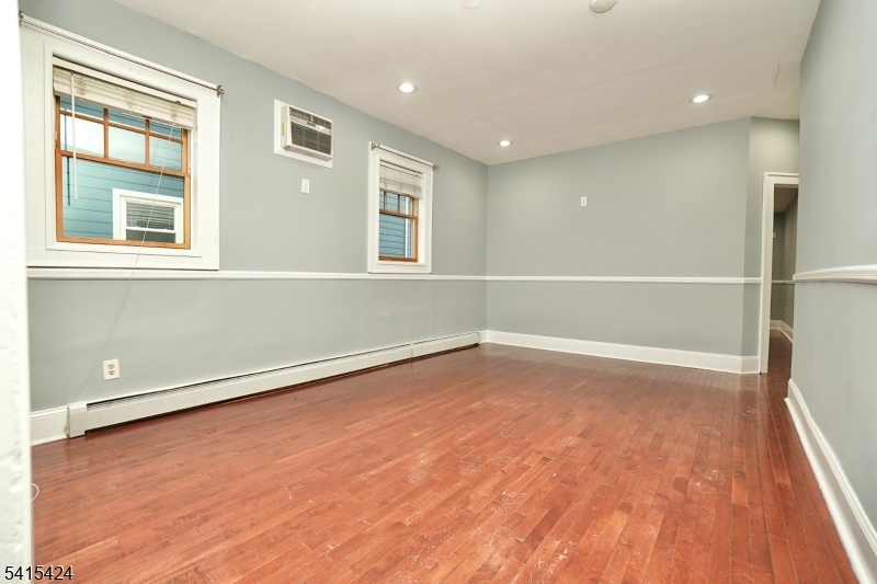 81 Berkeley Avenue Bloomfield, NJ 07003 - Photo 4 of 43 a view of an empty room with wooden floor and a window
