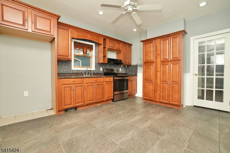 81 Berkeley Avenue Bloomfield, NJ 07003 - Photo 6 of 43 an empty room with windows cabinet and a kitchen