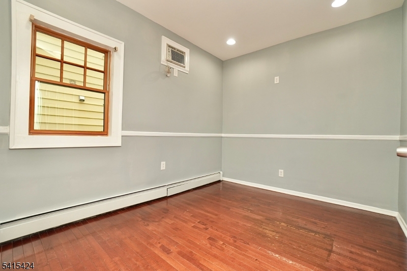 81 Berkeley Avenue Bloomfield, NJ 07003 - Photo 8 of 43 an empty room with wooden floor and windows